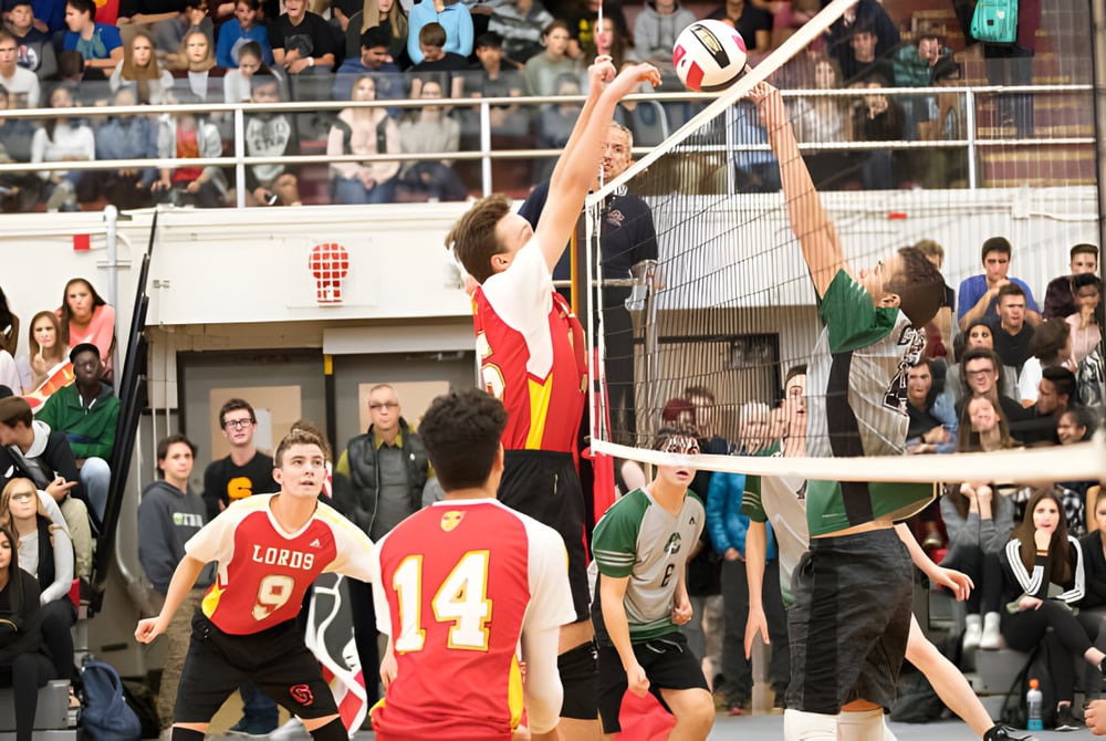 Eine Gruppe von Schülerinnen und Schülern der Strathcona High School spielt Volleyball vor Zuschauern in der Sporthalle.