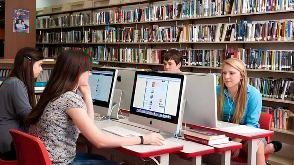 Eine Gruppe junger Schülerinnen arbeitet an Computern in der Bibliothek der Stuart Hall School.