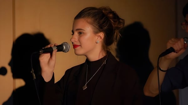 Eine junge Schülerin singt mit Mikrofon auf der Bühne der Collège Sturgeon Heights Collegiate.