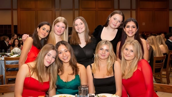 Eine Gruppe junger Frauen in formeller Kleidung posiert gemeinsam auf einer Veranstaltung in der Suffield Academy.