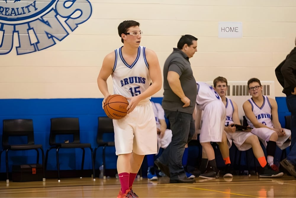Ein Basketballspieler in blauem Trikot steht mit Ball auf dem Basketballfeld der Sugarloaf Senior High.