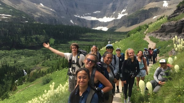 Eine Gruppe von Schülerinnen und Schülern der Sugarloaf Senior High wandert auf einem Pfad in einer bergigen Landschaft.