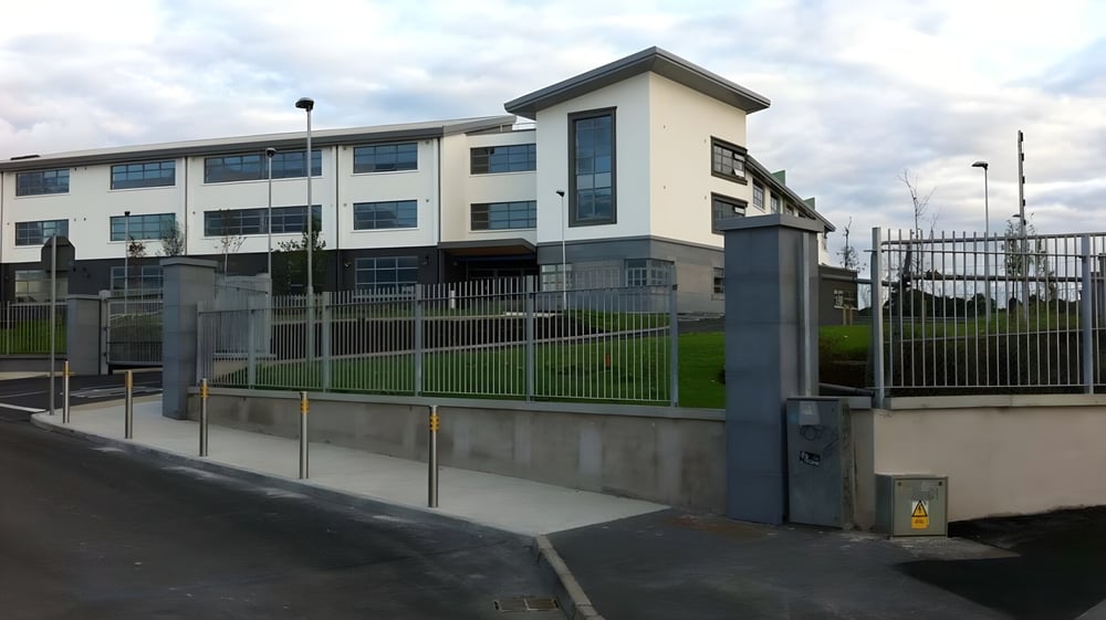 Das moderne mehrstöckige Gebäude mit Eingang und Rasenfläche auf dem Campus des Summerhill College unter bewölktem Himmel.