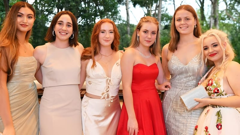 Sechs Schülerinnen mit roten Haaren stehen gemeinsam im Grünen auf dem Gelände der Sunshine Beach State High School.