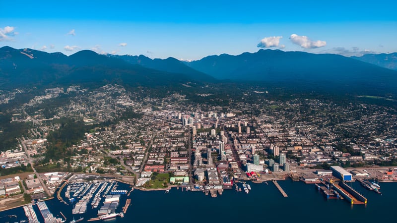 Die urbanen Bereiche mit Hafen und Hochhäusern vor den Bergen in der Umgebung von Sutherland Secondary School.