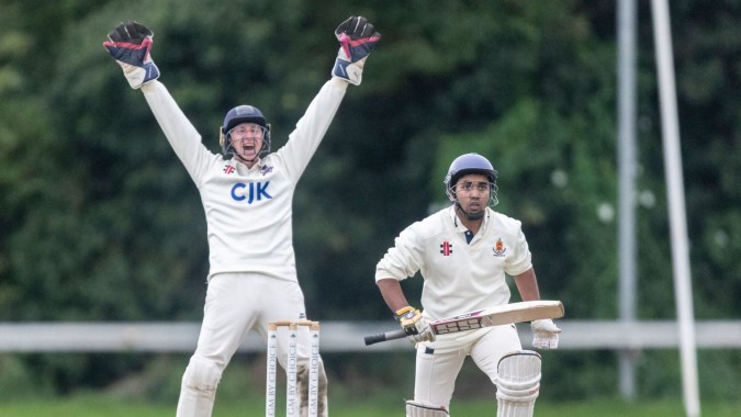Zwei Cricketspieler der Sutton Park School auf dem Spielfeld, einer jubelt mit erhobenen Armen, der andere hält einen Schläger.