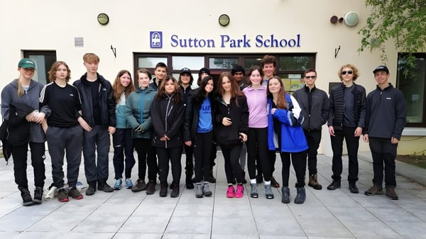 Eine Gruppe Schülerinnen und Schüler steht vor dem Gebäude der Sutton Park School in Dublin.