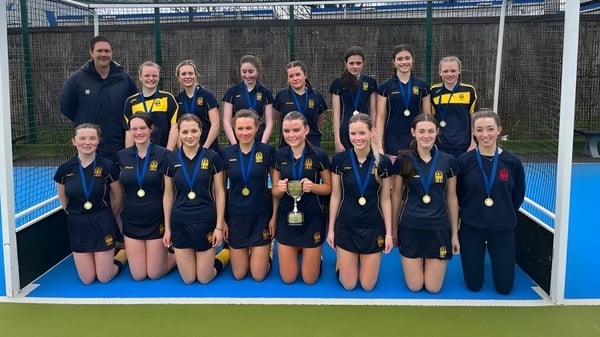 Eine Gruppe junger Sportlerinnen posiert gemeinsam auf dem Kunstrasenfeld der Sutton Park School in Dublin.