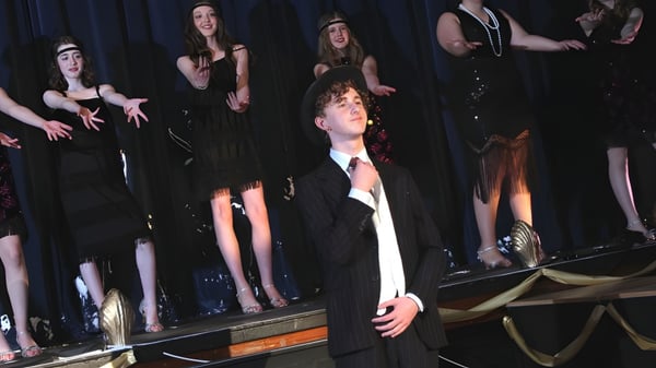 Eine Gruppe von Schülerinnen und Schülern der Sutton Valence School steht auf einer Bühne vor einem dunklen Vorhang.