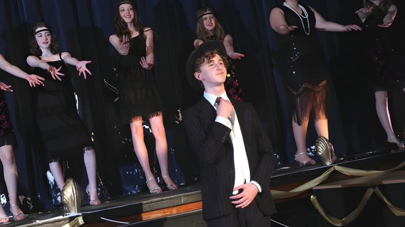 Eine Gruppe von Schülerinnen und Schülern der Sutton Valence School steht auf einer Bühne vor einem dunklen Vorhang.