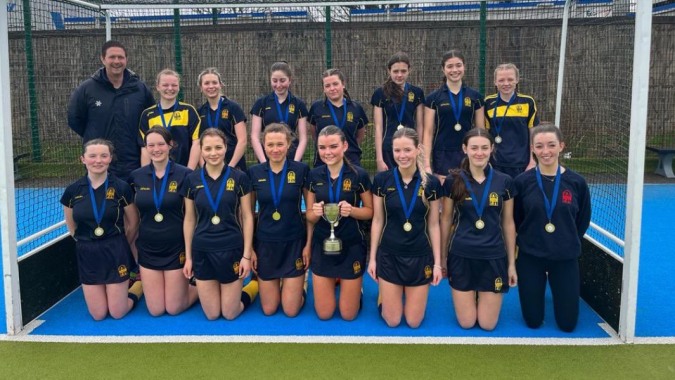 Eine Gruppe junger Athletinnen im Sportdress posiert auf dem Sportplatz der Sutton Park School in Dublin.