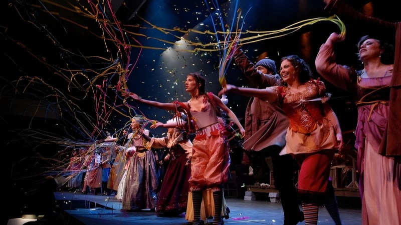 Schülerinnen und Schüler der Sydenham High School führen ein farbenfrohes und dynamisches Tanzstück auf einer Bühnenkulisse mit Lichteffekten auf.