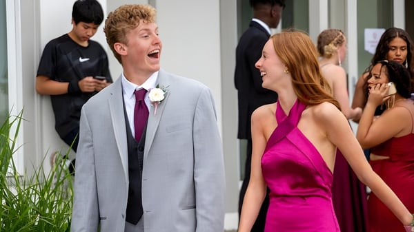 Ein junges Paar steht bei einer formellen Veranstaltung vor einer Gruppe von Menschen auf dem Campus der Tabor Academy.