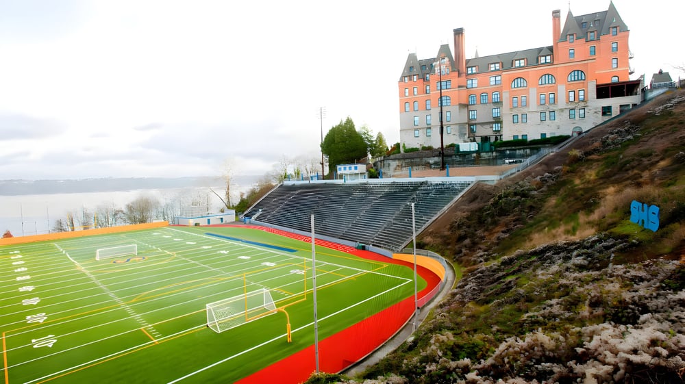 Das bunte Sportfeld mit einem Fußballtor und einer hügeligen Landschaft im Hintergrund auf dem Campus der Tacoma Public Schools.