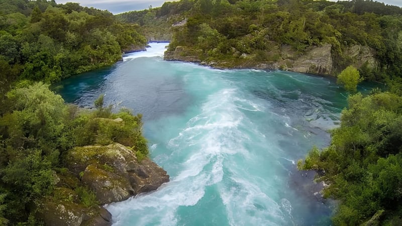 Ein türkisfarbener Fluss fließt durch einen felsigen Canyon inmitten einer bewaldeten Landschaft nahe dem Tauhara College.