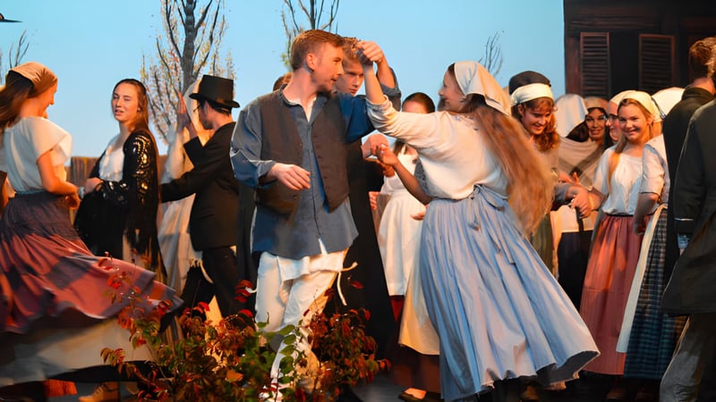 Eine Gruppe von Menschen in formeller und traditioneller Kleidung bei einer Feier auf dem Campus der Taradale High School.