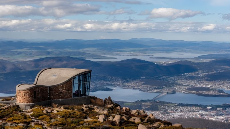 Eine steinerne Struktur auf einem Felsen bietet eine Aussicht auf die Stadt und die umliegenden Berge bei Taroona High School.