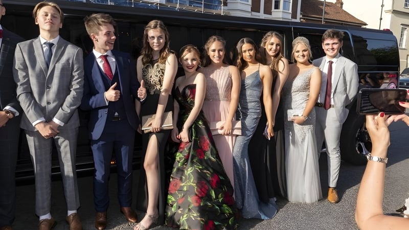 Eine Gruppe gut gekleideter Personen steht vor einem Gebäude auf dem Campus der Taunton School.