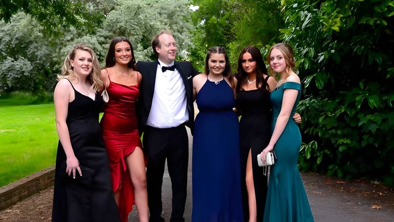 Eine Gruppe elegant gekleideter Personen posiert im Grünen auf dem Campus der Taunton School International.