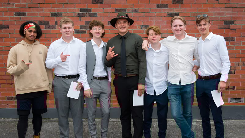 Eine Gruppe Schüler steht vor einer Backsteinmauer auf dem Gelände des Taupo-nui-a-Tia College.