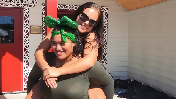 Zwei Personen umarmen sich in einem Innenraum auf dem Campus der Te Puke High School.