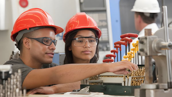 Zwei Schülerinnen und Schüler der Technical Vocational High School untersuchen Werkzeuge in der Werkstatt.