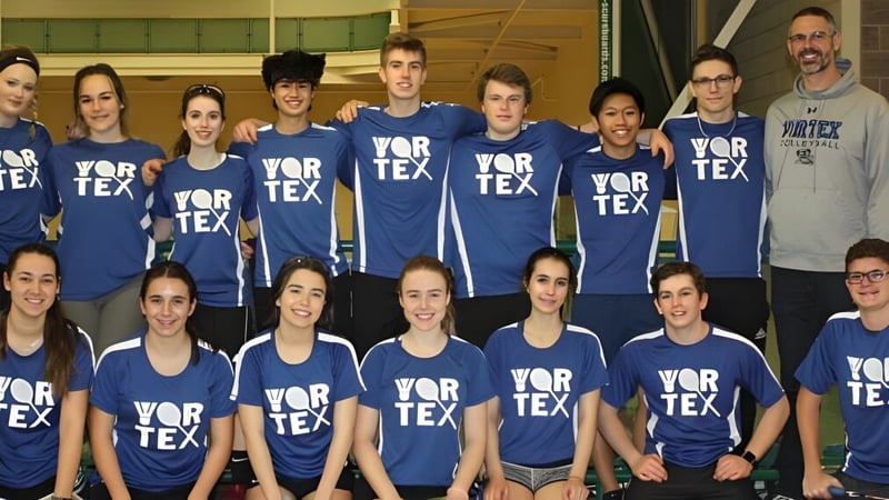 Eine Gruppe von Schülerinnen und Schülern der Tecumseh Vista Academy steht gemeinsam in einem Sportzentrum und trägt blaue Shirts mit dem Schriftzug VORTEX.