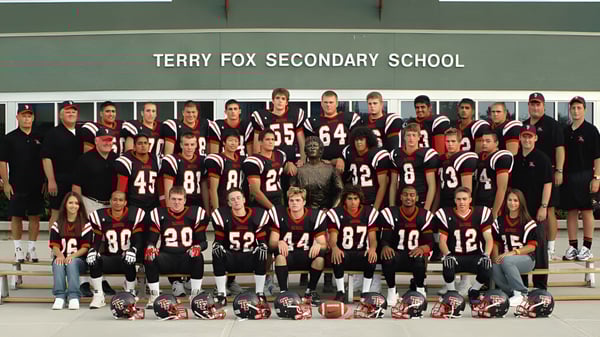 Eine Gruppe von Schülerinnen und Schülern der Terry Fox Secondary School posiert vor einem Banner mit dem Schulnamen im Hintergrund.