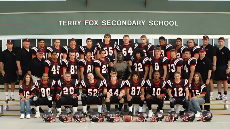 Eine Gruppe von Schülerinnen und Schülern der Terry Fox Secondary School posiert vor einem Banner mit dem Schulnamen im Hintergrund.