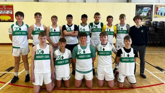 Schüler der The Abbey School posieren in ihren Basketballtrikots in der Sporthalle.