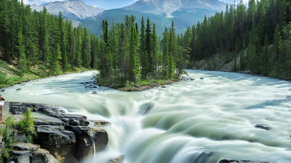 Der Fluss mit rauschendem Wasser und schneebedeckten Bergen ist in der Nähe von The Bishop Strachan School zu sehen.
