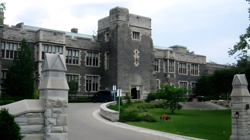 Das imposante steinerne Gebäude der The Bishop Strachan School steht umgeben von gepflegtem Rasen mit einem Weg zum Eingang.