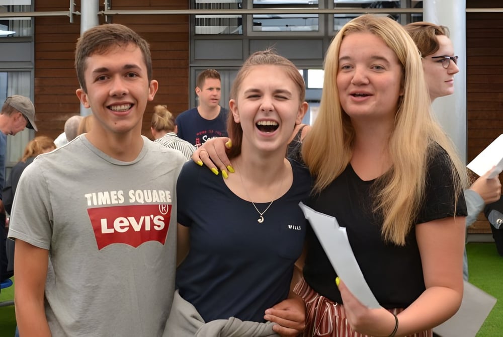 Eine Gruppe von Schülern steht vor einem Backsteingebäude auf dem Campus der The Bourne Academy.