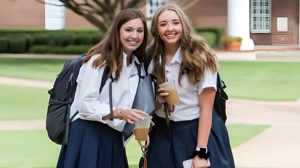 Zwei Schülerinnen der The Brook Hill School stehen zusammen im Freien vor einem Backsteingebäude.