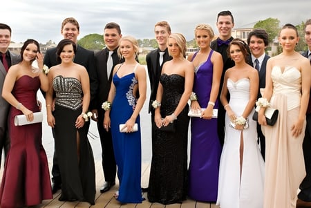 Eine Gruppe formal gekleideter Personen steht im Freien mit der Stadtsilhouette im Hintergrund auf dem Campus der The Friends’ School.