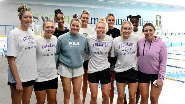 Eine Gruppe junger Schülerinnen der The Friends’ School steht gemeinsam in der Schwimmhalle in einheitlichen Sportanzügen.