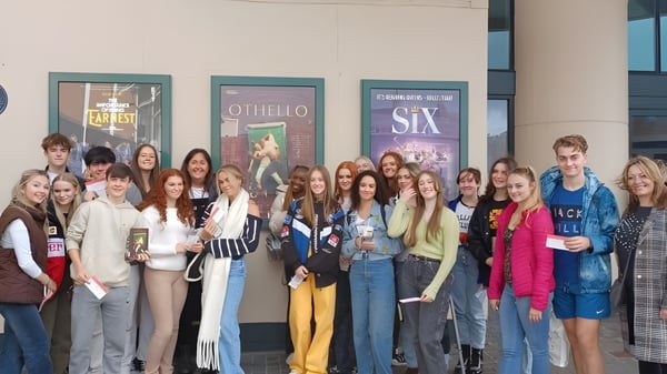 Schülerinnen und Schüler der The Hammond School stehen vor einem Theater mit Plakaten zu den Stücken Othello und Sex.