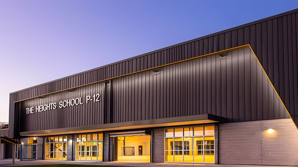 Das große Gebäude mit der Aufschrift The Heights School P-12 vor klarem blauem Himmel.