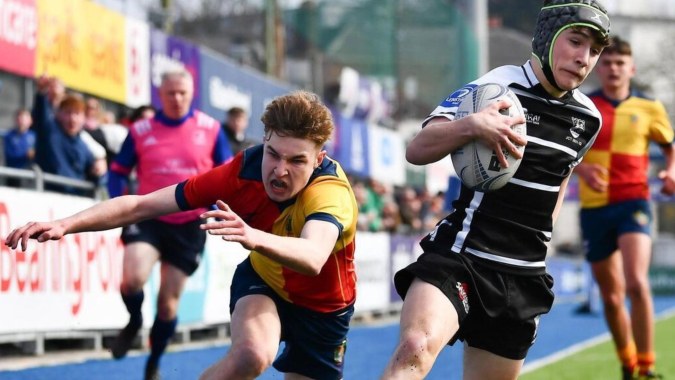 Zwei Rugbyspieler kämpfen auf dem Sportfeld während eines Spiels auf dem Campus der The High School.