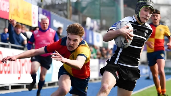 Zwei Sportler treten in Sportuniformen bei einem Wettkampf auf dem Sportfeld der The High School an.