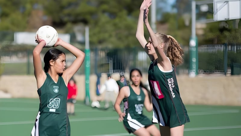 Zwei Basketballspielerinnen spielen auf dem Basketballfeld der The Hills Grammar School.