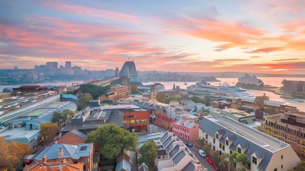 Eine lebendige Stadtlandschaft mit bunten Gebäuden und einem geschäftigen Hafen im Sonnenuntergang, nicht direkt an der The Hills Grammar School gelegen.