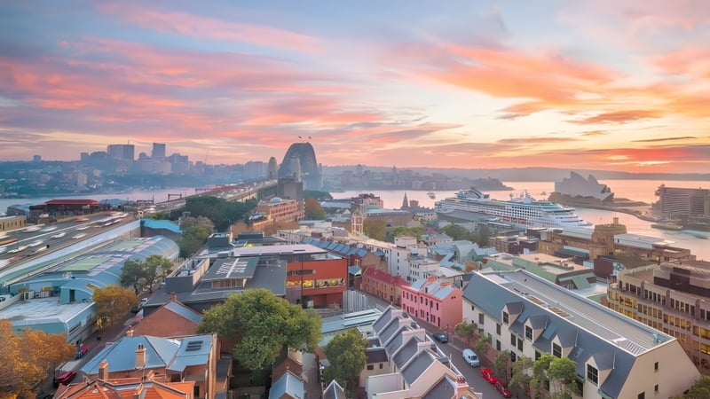 Eine lebendige Stadtlandschaft mit bunten Gebäuden und einem geschäftigen Hafen im Sonnenuntergang, nicht direkt an der The Hills Grammar School gelegen.