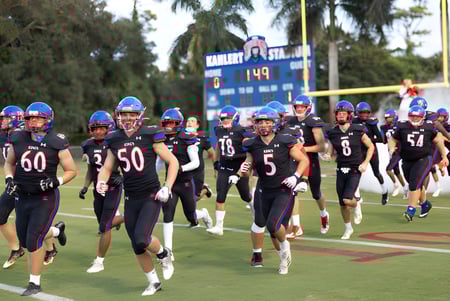 Eine Gruppe von Fußballspielern in Uniform läuft gemeinsam auf dem Sportplatz der The King's Academy.