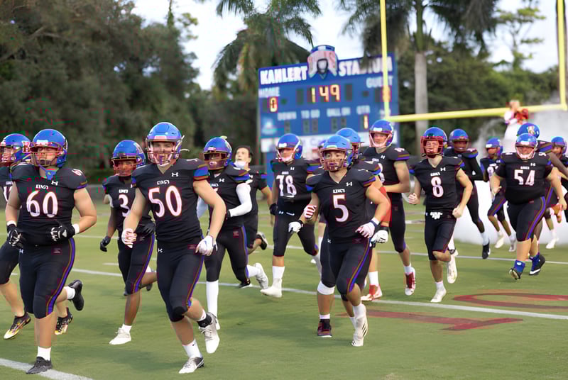 Eine Gruppe von Fußballspielern in Uniform läuft gemeinsam auf dem Sportplatz der The King's Academy.