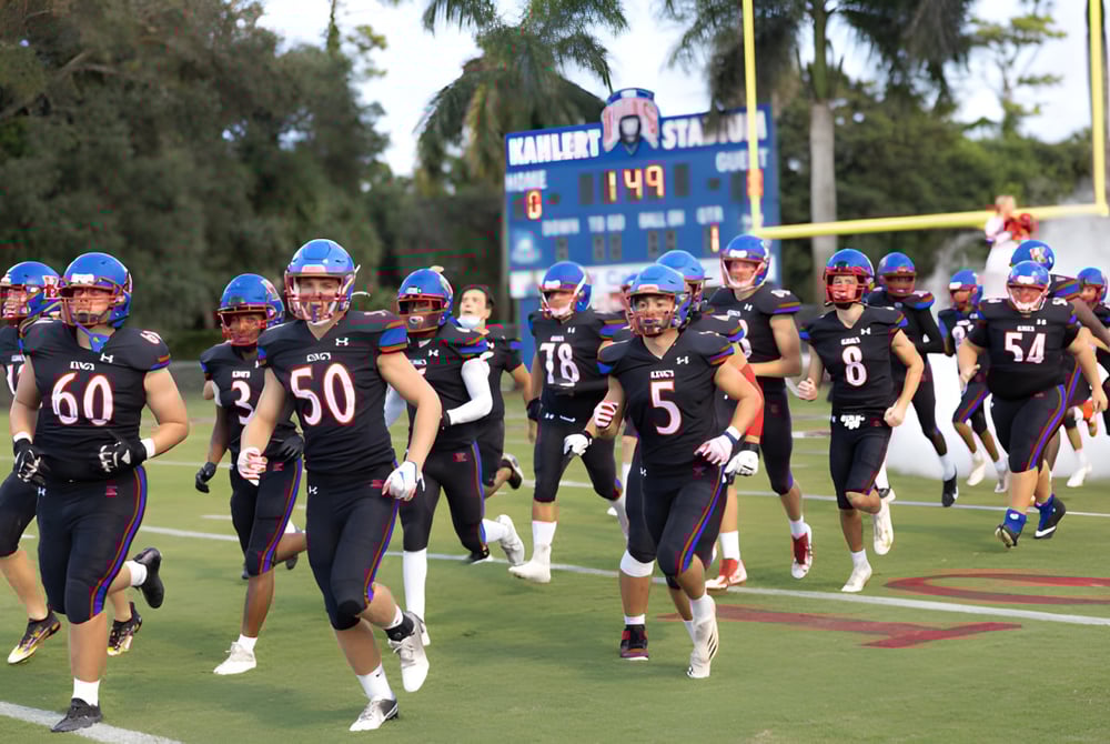 Eine Gruppe von Fußballspielern in Uniform läuft gemeinsam auf dem Sportplatz der The King's Academy.