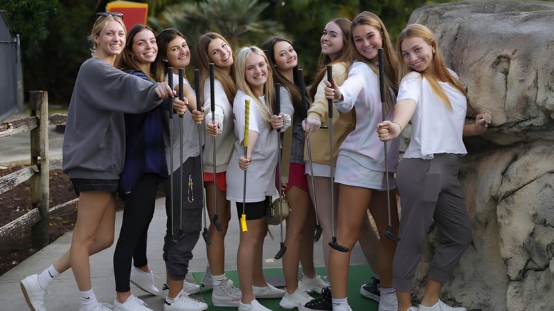 Eine Gruppe Schülerinnen steht gemeinsam vor einem felsigen Hintergrund auf dem Gelände der The King's Academy.