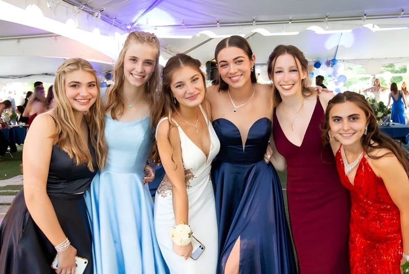 Eine Gruppe junger Schülerinnen der The Kings Hospital posiert im festlichen Freiluftambiente mit bunten Luftballons im Hintergrund.