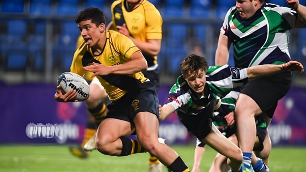 Schüler der The Kings Hospital spielen Rugby und kämpfen bei einem Tackle auf dem Spielfeld.