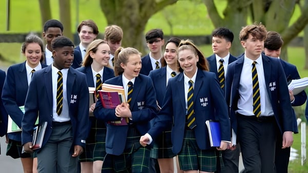 Eine Gruppe Schüler der The Kings Hospital geht auf einem Weg umgeben von grüner Natur.